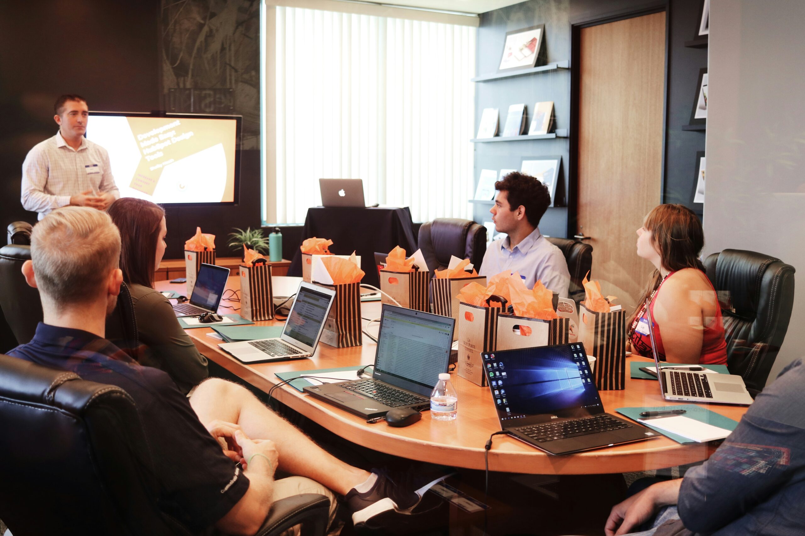 Team meeting with laptops and presentation screen